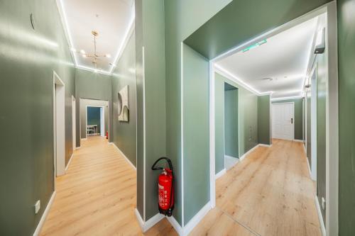 a hallway with green walls and a red fire extinguisher at HOME1 - Augarten City Stay Boutique Hostel in Vienna