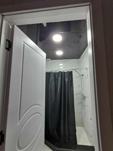 a bathroom with a shower with a black shower curtain at Ande Tower Apartment on Zgvispiris Street #6, Batumi in Minda