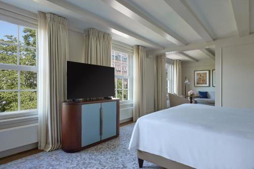 a bedroom with a bed and a flat screen tv at Waldorf Astoria Amsterdam in Amsterdam
