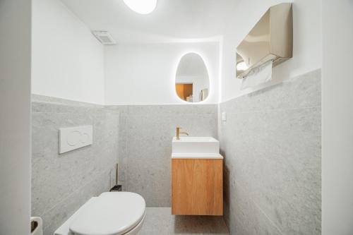 a bathroom with a white toilet and a sink at HOME1 - Augarten City Stay Boutique Hostel in Vienna