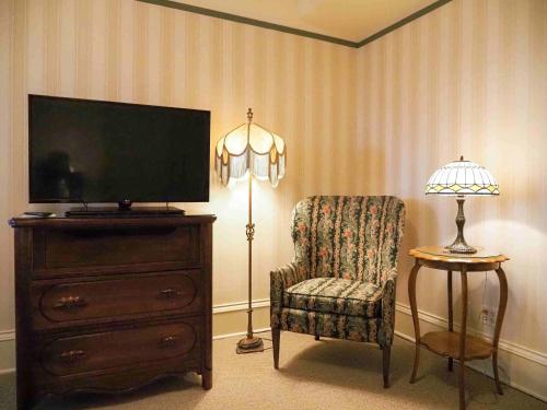 a living room with a tv and a chair and a lamp at Hotel Boulderado in Boulder