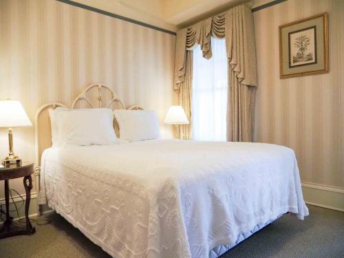 a bedroom with a white bed and a window at Hotel Boulderado in Boulder
