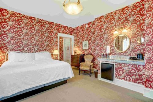 a bedroom with a bed and a bathroom with red wallpaper at Hotel Boulderado in Boulder