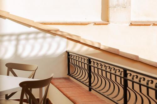 a balcony with a table and chairs and a window at PalazzoRusso Ortigia Suite & Apartments in Siracusa