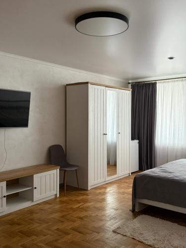 a bedroom with a bed and a desk and a tv at In hotel in Kamianets-Podilskyi
