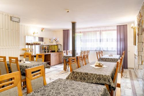 a restaurant with tables and chairs and a kitchen at Dom Wypoczynkowy Elżbieta in Poronin
