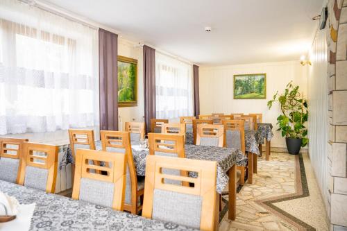 a restaurant with tables and chairs in a room at Dom Wypoczynkowy Elżbieta in Poronin