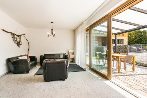 a living room with leather furniture and a sliding glass door at Hotel Helios in Lipova Lazne