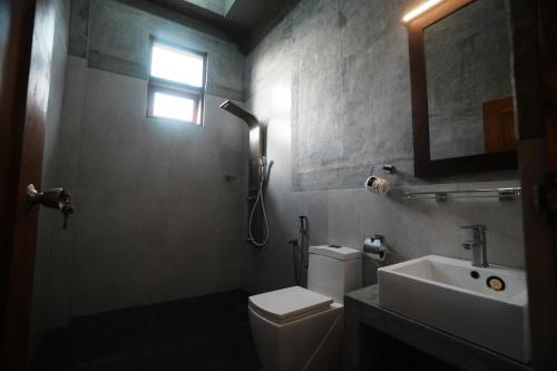 Un baño con inodoro, lavabo y ventana. en Rise & Set Arugam bay, en Arugam Bay