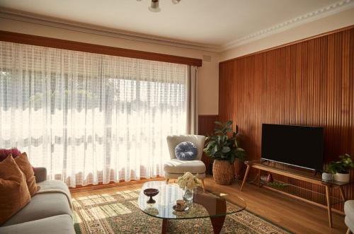 a living room with a couch and a tv at Ultimate 70s Charm near Geelong Waterfront and CBD in Bell Post Hill