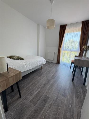 a bedroom with a bed and a desk and a piano at DOMITYS - La Florentine in Sarreguemines
