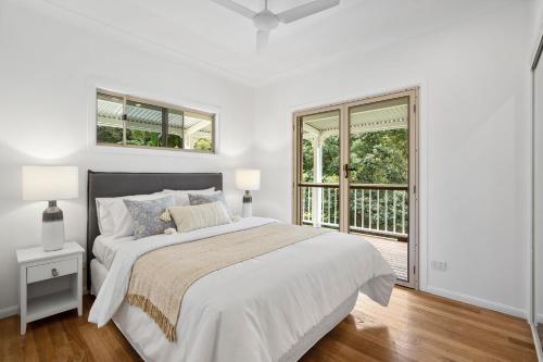 a white bedroom with a bed and a window at Montville Retreat offgrid luxury in Montville