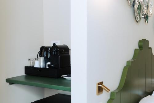 a coffee maker on a green shelf in a room at PalazzoRusso Ortigia Suite & Apartments in Siracusa