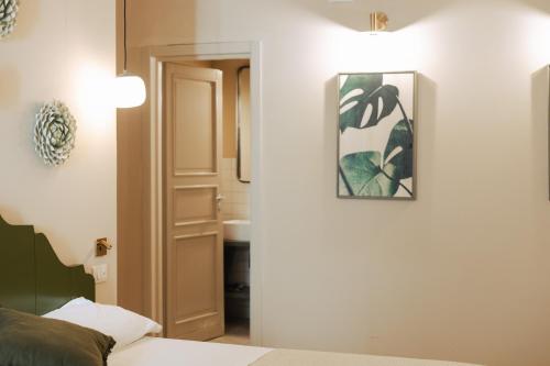 a bedroom with a bed and a picture on the wall at PalazzoRusso Ortigia Suite & Apartments in Siracusa