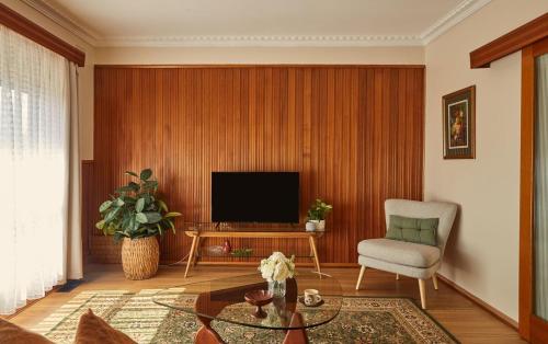 a living room with a television and a chair at Ultimate 70s Charm near Geelong Waterfront and CBD in Bell Post Hill