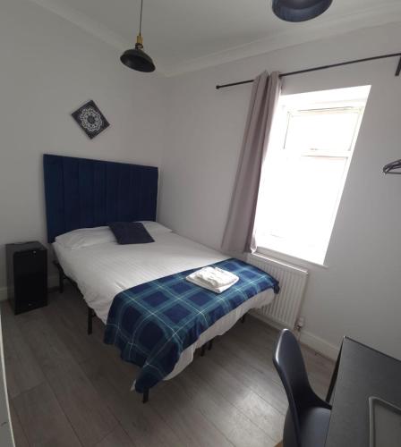 a bedroom with a bed and a desk and a window at Golders Park Hotel in London