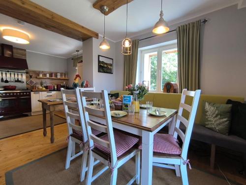 Una cocina y una sala de estar con mesa y sillas. en Natur und Wellness ''auf der Hardt'' -Jacuzzi- Sauna- Kinderausstattung- Alleinlage im Wald, en Mürlenbach