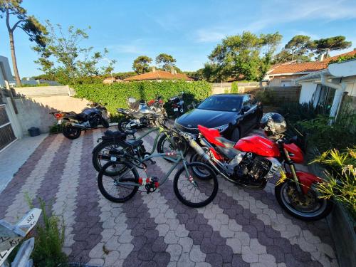 a group of motorcycles and bikes parked in a driveway at La Maison Bisca in Biscarrosse-Plage