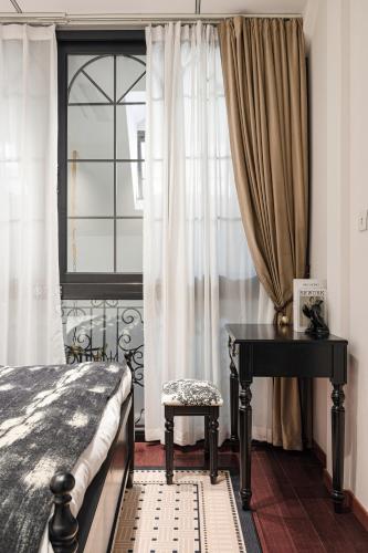 a bedroom with a bed and a desk and a window at A detached, old Shanghai villa on Huaihai Middle Road in Shanghai
