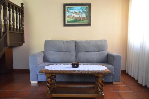 a living room with a blue couch and a coffee table at LAS ATAZADAS in Villanueva de Pría