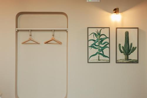 a bathroom with two pictures of cactuses on the wall at PalazzoRusso Ortigia Suite & Apartments in Siracusa