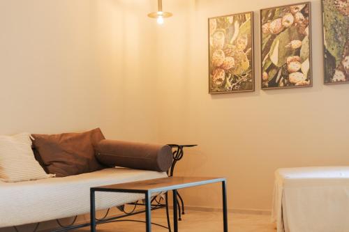 a living room with a couch and paintings on the wall at PalazzoRusso Ortigia Suite & Apartments in Siracusa