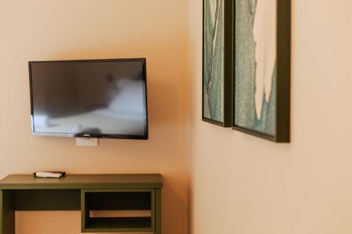 a flat screen tv hanging on a wall next to a table at PalazzoRusso Ortigia Suite & Apartments in Siracusa