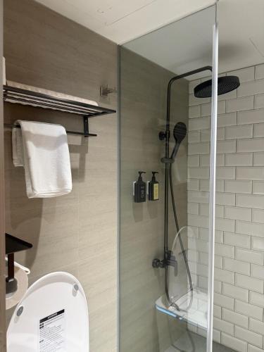 a bathroom with a shower with a toilet and a sink at Talmud Hotel Classic Taiwan Boulevard in Taichung