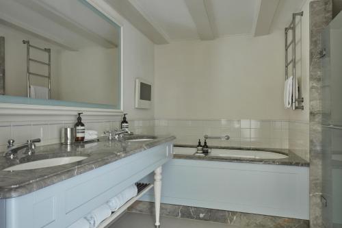 a bathroom with two sinks and a large mirror at Waldorf Astoria Amsterdam in Amsterdam