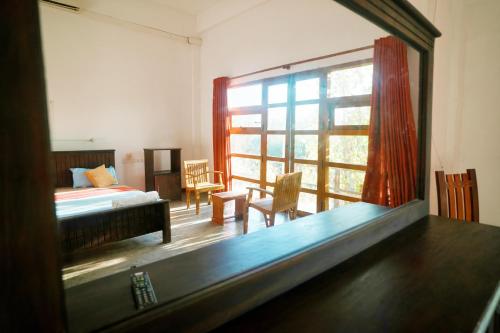 a room with a bed and a large window at Rise & Set Arugam bay in Arugam Bay