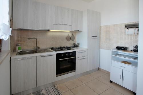 a kitchen with white cabinets and a stove top oven at Nuvole&Lenzuola in Pescara