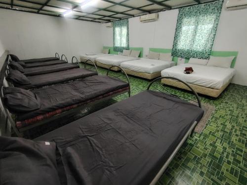 a room with several beds in a room with green floors at Casa Hotel near KLIA 1 in Sepang