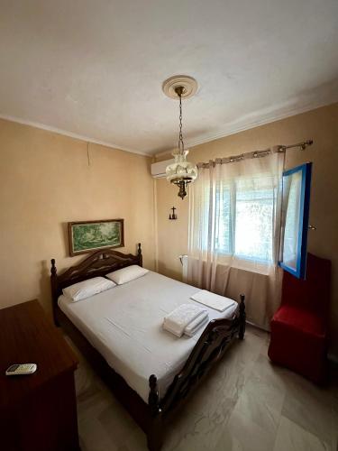 a bedroom with a bed and a window and a chandelier at Ikidiki Beach Villa in Ierissos