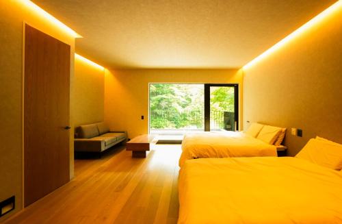 a hotel room with two beds and a window at 郷音 The Summit Club in Tsuru 
