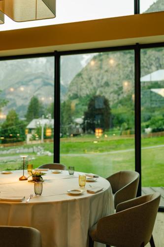 a dining room with a table and chairs and a large window at Grand Hotel Courmayeur Mont Blanc, by R Collection Hotels in Courmayeur