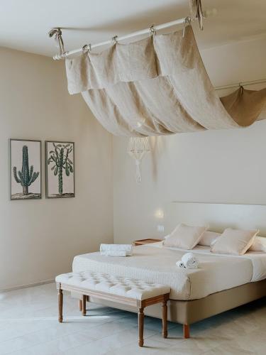 a bed with a canopy in a white room at PalazzoRusso Ortigia Suite & Apartments in Siracusa