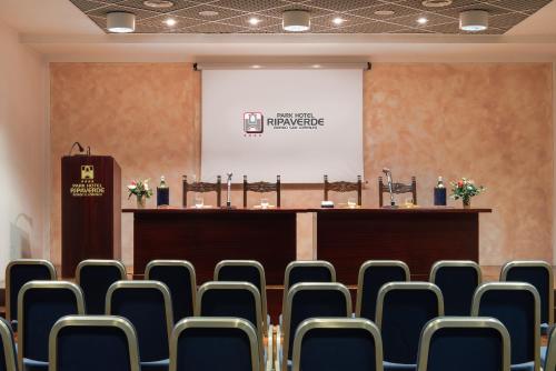 a conference room with chairs in front of a podium at Park Hotel Ripaverde in Borgo San Lorenzo