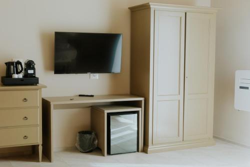 a room with a tv and a desk with a mirror at PalazzoRusso Ortigia Suite & Apartments in Siracusa