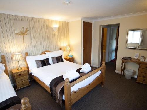 a bedroom with a large bed with towels on it at The Heath Inn in Leighton Buzzard