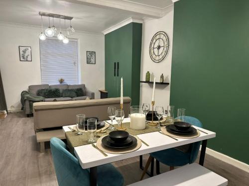 a dining room with a table and a couch at Bright and Spacious Home Near Bridgend Town Centre in Bridgend