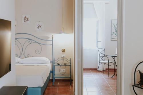 a small bedroom with a bed and a mirror at PalazzoRusso Ortigia Suite & Apartments in Siracusa