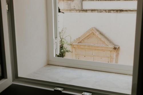 a window with a view of a house at PalazzoRusso Ortigia Suite & Apartments in Siracusa