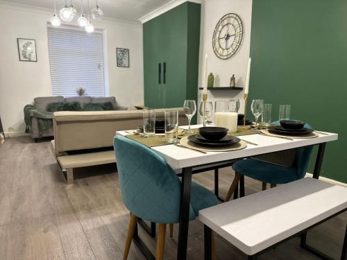 a living room with a table with chairs and a couch at Bright and Spacious Home Near Bridgend Town Centre in Bridgend
