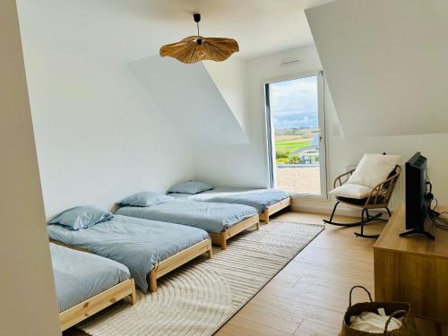 a room with three beds and a window at Maison neuve proche des plages in Plouarzel