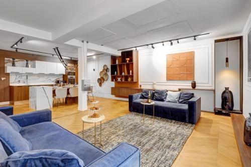 パリにあるBluestay 165 - Spacieux Appartement à Parisの青いソファとキッチンのあるリビングルーム