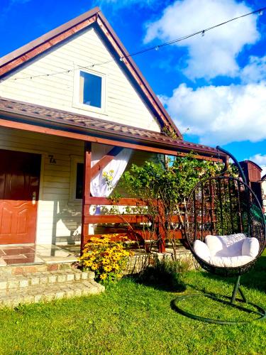 a swing in front of a house at Domki Rainer's in Dębki