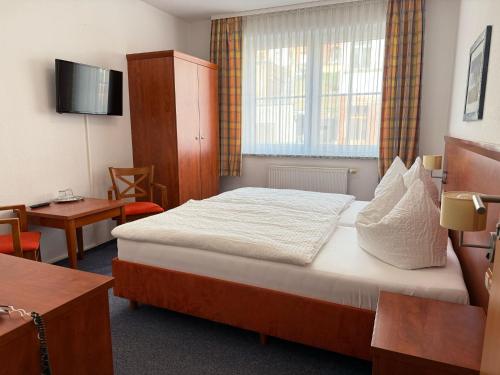 a hotel room with a bed and a desk at Hotel am Hafen Havelberg in Havelberg
