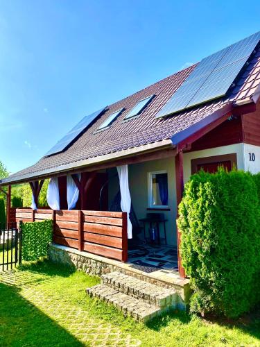 a house with solar panels on the roof at Domki Rainer's in Dębki