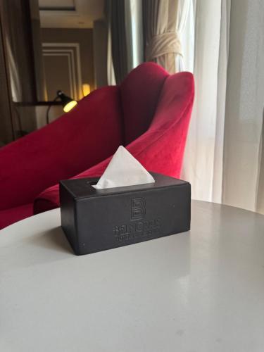 a black box sitting on a table with a red chair at The Belmorris in Multan