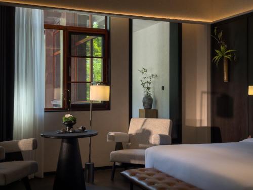 a bedroom with a bed and a chair and a window at FunGeeS in Zhangjiajie